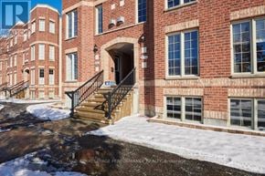 Ottawa townhouse for rent - A red brick building with a black railing and steps leading to the entrance.