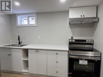 Niagara Falls (Church's Lane) apartment for rent - A white kitchen with a sink and an oven.