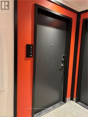 Waterloo condo for rent - A black door with a silver handle and a sign on the wall above it.