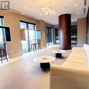 Oshawa (Windfields) condo for rent - A modern living room with a white sofa and a round table.