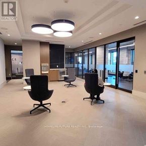 Oshawa (Windfields) condo for rent - A spacious office with black chairs and a wooden cabinet.