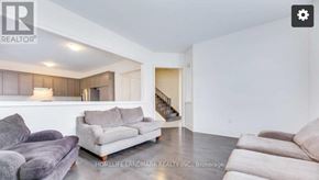 Oakville (Jm Joshua Meadows) apartment for rent - A living room with a grey couch and a wooden cabinet.