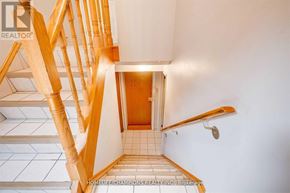 Toronto (Downsview-Roding-Cfb) apartment for rent - A wooden staircase with a tiled floor leading to a door.