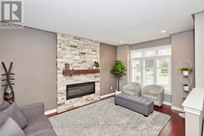 Welland (Coyle Creek) apartment for rent - A living room with a stone fireplace and grey couch.