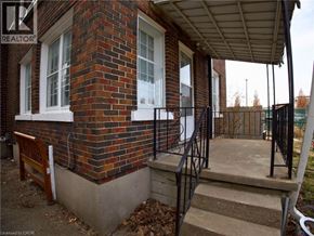 Woodstock apartment for rent - A brick house with a porch and a black railing.