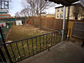 Woodstock apartment for rent - A backyard with a black fence and a green tree.
