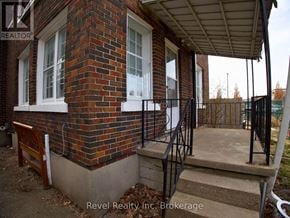 Woodstock (Woodstock - South) triplex for rent - A house with a brick wall and a porch.