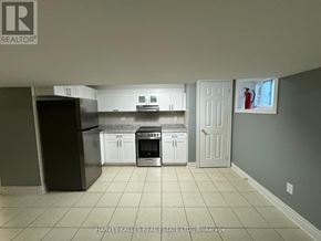 Toronto (Dovercourt-Wallace Emerson-Junction) apartment for rent - A kitchen with white cabinets and a black fridge is shown.