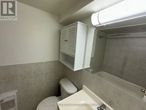 Toronto (Dovercourt-Wallace Emerson-Junction) apartment for rent - A bathroom with a toilet, a cabinet, and a shower.