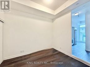 Toronto (Birchcliffe-Cliffside) condo for rent - A room with white walls and wooden flooring, with a mirror on the wall.