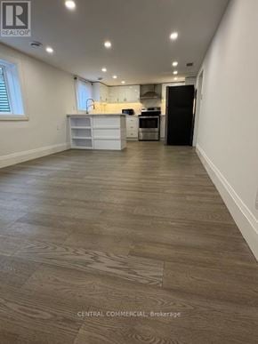 Aurora (Aurora Highlands) apartment for rent - A spacious kitchen with a black refrigerator and white cabinets.