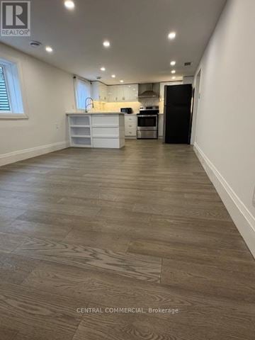 Aurora (Aurora Highlands) apartment for rent - A spacious kitchen with a black refrigerator and white cabinets.