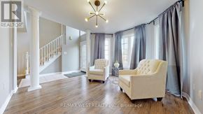 Barrie (East Bayfield) apartment for rent - A spacious living room with a staircase and two chairs.