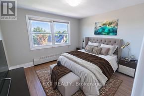 St. Catharines (E. Chester) multi-family for rent - A bedroom with a large bed and a painting on the wall.