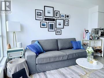 Toronto (Bayview Village) condo for rent - A grey couch with blue pillows sits in a living room with a white coffee table in front of it.