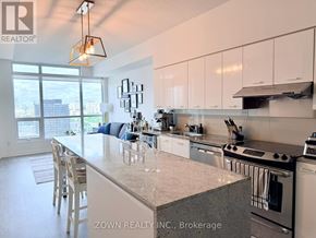 Toronto (Bayview Village) condo for rent - A kitchen with a large island and a view of the city.