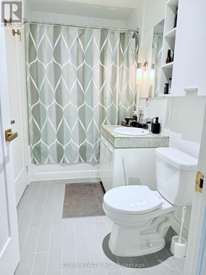Toronto (Bayview Village) condo for rent - A white toilet in a bathroom with a glass shower curtain.