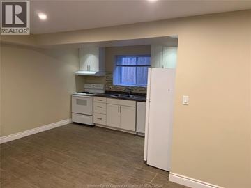 Windsor apartment for rent - A kitchen with white cabinets and appliances in a room with beige walls.