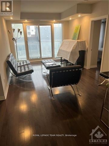 Ottawa condo for rent - A living room with a black couch and a white chair.