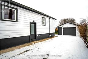 Hamilton (Burkholme) apartment for rent - A white house with a black door and a garage door is shown in the image.