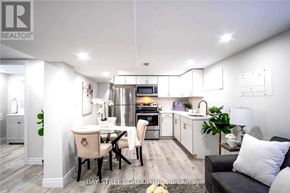 Hamilton (Burkholme) apartment for rent - A well-lit, modern kitchen and dining area with a black sofa and a wooden floor.