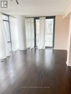 Toronto (Bay Street Corridor) condo for rent - A room with wooden flooring and white curtains.