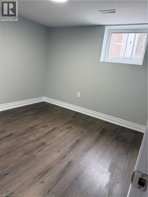Hamilton apartment for rent - A room with a window and wooden flooring.