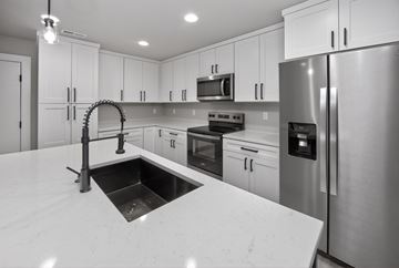 Urbandale apartment for rent - A modern kitchen with a sink and stainless steel appliances.