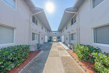 Lake Park apartment for rent - A sunny day in a long, narrow courtyard between two rows of identical buildings.