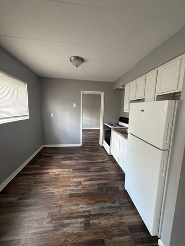Cincinnati apartment for rent - A kitchen with a white fridge and wooden floors.