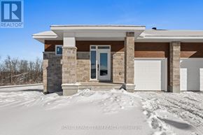 Brockville apartment for rent - A house with a white garage door and a blue door is surrounded by snow.