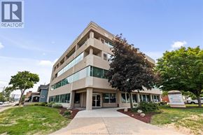 Windsor apartment for rent - A modern building with a glass facade and a sign that reads REALTOR.