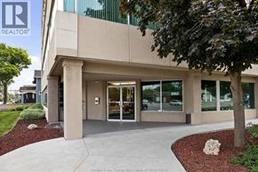 Windsor apartment for rent - A building with a glass door entrance and a tree in front.
