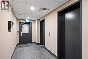 Windsor apartment for rent - A hallway with a black door on the right and a black door with a red sign on the left.