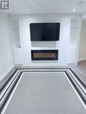 Vaughan (Maple) apartment for rent - A modern living room with a fireplace and a flat screen TV mounted on the wall.