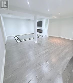 Vaughan (Maple) apartment for rent - A spacious room with a grey floor and a black and white rug.