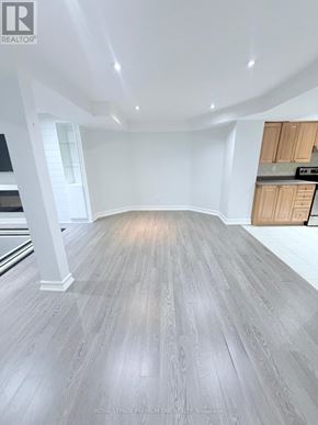 Vaughan (Maple) apartment for rent - A spacious room with wooden flooring and white walls.
