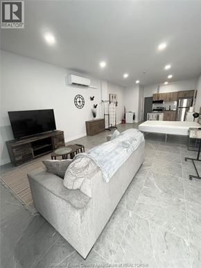 Windsor apartment for rent - A living room with a couch, television, and a wall clock.