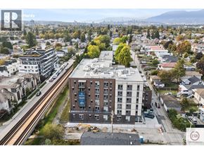 Vancouver apartment for rent - A cityscape with a large building in the foreground and a highway in the background.