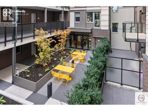 Vancouver apartment for rent - A patio with a table and chairs is surrounded by a fence and a building.