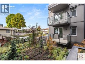 Vancouver apartment for rent - A modern apartment building with a balcony and a garden in front.