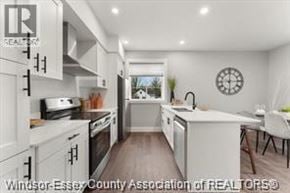 Essex apartment for rent - A kitchen with white cabinets and a clock on the wall.