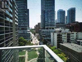 Toronto (Mount Pleasant West) condo for rent - A view of a city from a balcony with buildings and a road.