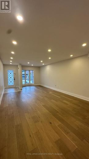 Toronto (Weston) apartment for rent - A spacious room with wooden flooring and recessed lighting.