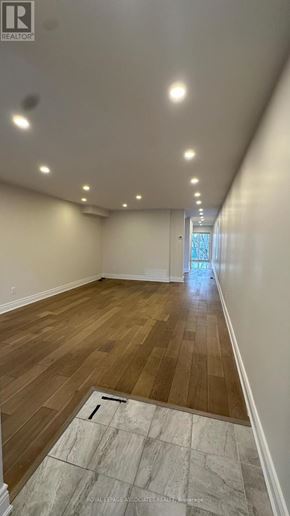 Toronto (Weston) apartment for rent - A long, empty hallway with wooden floors and white walls.