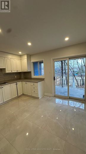 Toronto (Weston) apartment for rent - A spacious kitchen with white cabinets and a tiled floor.