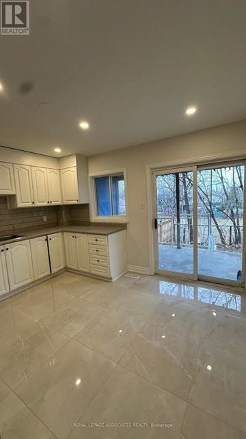 Toronto (Weston) apartment for rent - A spacious kitchen with white cabinets and a tiled floor.
