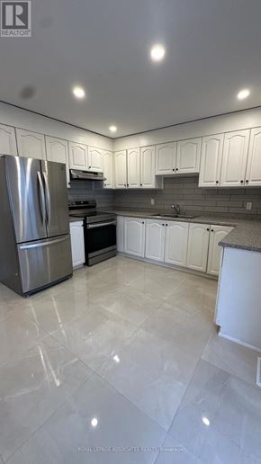 Toronto (Weston) apartment for rent - A modern kitchen with white cabinets and a marble floor.