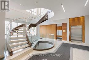 Markham (Commerce Valley) condo for rent - A modern interior space with a curved staircase and glass railings.