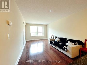Markham (Commerce Valley) condo for rent - A living room with a couch and a window.